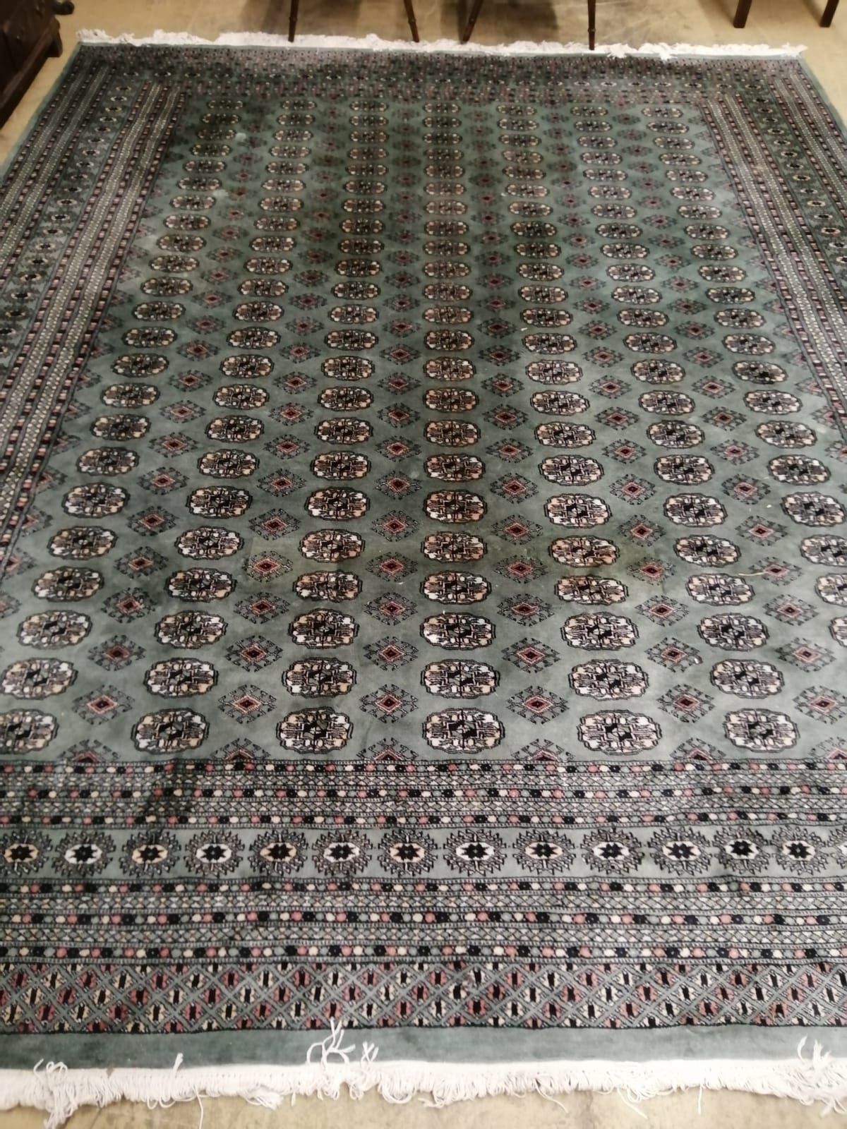 A Pakistan Bokhara green ground carpet, 350 x 282cm